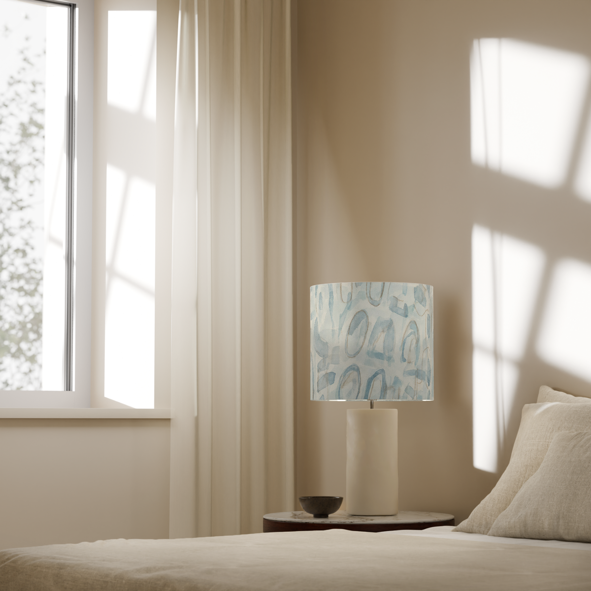 Mica Mineral Abstract Drum Lampshade — 10″ Diameter; shade on a lamp in a styled bedroom; lamp base and furniture are styling only.